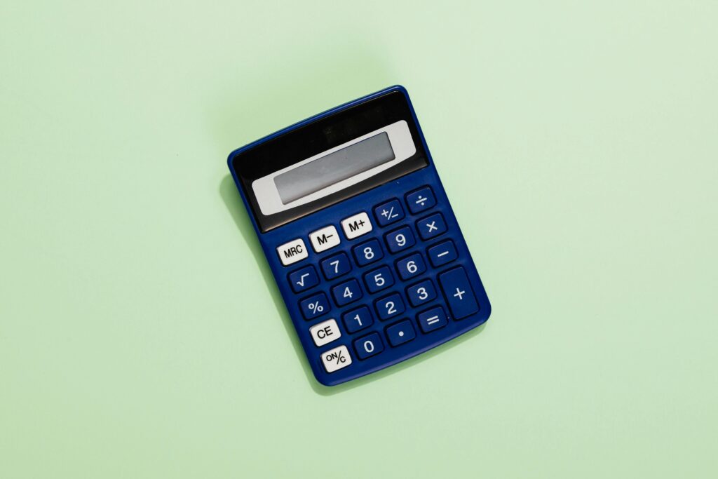 A blue calculator placed on a light green background. Ideal for financial and educational themes.